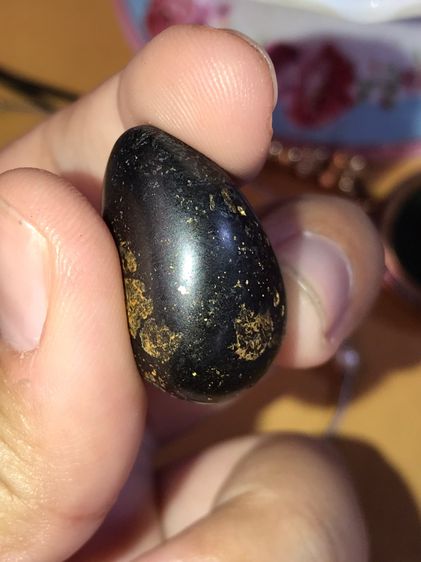 เหล็กไหล รูปหยดน้ำ ขนาดประมาณ 1 นิ้ว ใหญ่เท่ากับเม็ดขนุน เป็นเหล็กไหลปิดทอง มีลักษณะเป็นก้อนสีดำนิลอมเขียวปีกแมลงทับปนดำ เป็นมันด้านๆ ไม่แวว รูปที่ 8