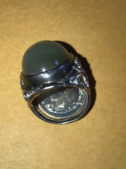 เพชรตาแมว ทำเป็นหัวแหวน แบบหลังเต่า ใส่แหวนเงิน ลายดอกพุฒตาล เส้นผ่าศูนย์กลางประมาณ 2 ซม. สีตุ่นๆ ออกอมดำ และสีขาวขุ่น ลักษณะเป็นชั้นๆของวงส รูปที่ 16