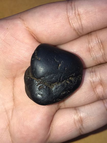 เหล็กไหล ทรงมน สีดำสลับสีน้ำตาล มีลายเป็นธรรมชาติ ขนาดประมาณ 1 นิ้ว มีน้ำหนัก จะมีลักษณะเนื้อเนียน ระเอียด ทรงสวยมาก มันเงา เก่าจริง ไม่คมมื รูปที่ 2