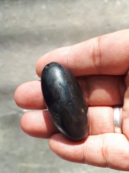 เหล็กไหล ทรงยาวรี สีดำสลับสีน้ำตาล มีลายเป็นธรรมชาติ ขนาดประมาณ 2 นิ้ว มีน้ำหนักมาก จะมีลักษณะเนื้อระเอียด มีรูตรงด้านหัวสำหรับเป็นทางเข้า อ รูปที่ 13