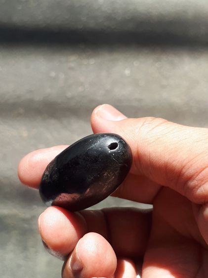 เหล็กไหล ทรงยาวรี สีดำสลับสีน้ำตาล มีลายเป็นธรรมชาติ ขนาดประมาณ 2 นิ้ว มีน้ำหนักมาก จะมีลักษณะเนื้อระเอียด มีรูตรงด้านหัวสำหรับเป็นทางเข้า อ รูปที่ 7