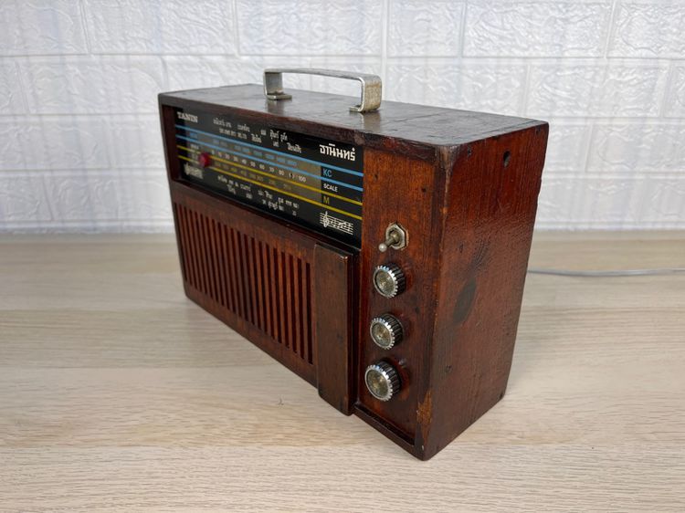 วิทยุทรานซิสเตอร์ธานินทร์ AM วินเทจ ตัวเครื่องทำจากไม้แท้ ผลิตในประเทศไทยยุคสงครามเย็น หน้าปัทม์มีชื่อสถานีต่าง ๆ ในช่วงเวลานั้นเป็นภาษาไทย รูปที่ 2