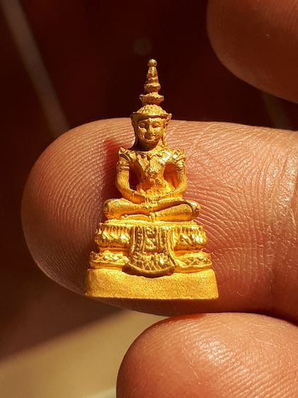 พระแก้วมรกต วัดพระแก้ว ตอกโค็ดนะ 1 ตัวที่ฐานผ้าทิพย์ ไม่ทราบปี เนื้อทองแดงพ่นราย สีเหมือนทองคำ น้ำหนัก 3.02 กรัม. สวย สมบูรณ์ เก่า แท้ หายาก