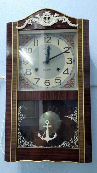 นาฬิกาแขวนผนังระบบไขลาน ยี่ห้อตราสมอ ลูกตุ้มสั้น ตัวเรือนไม้ เดินและระบบตีทำงานปกติ ลายน้ำสวย แขวนโชว์ในบ้าน เป็นเครื่องประดับบ้านได้อย่างดี