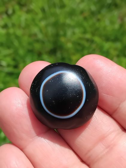 หินดวงตาสวรรค์ ทรงกลมแปดเลี่ยม พื้นสีดำ ตรงกลางมีเส้นวงกลมสีขาว เจาะรู ขัดมัน สีงดงามมากเม็ดนี้ โทนเข้มๆ ขนาดเส้นผ่าศูนย์กลาง 2.5 ซม. ขนาดพอ