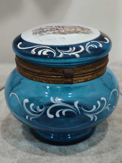 กระปุกแป้งน้ำเงิน ฝาบนภาพแสดงถึงสะพานอเล็กซานเดอร์ที่ 3 (Pont Alexandre III) ซึ่งเป็นสะพานที่สร้างขึ้นสำหรับงานนิทรรศการโลก 