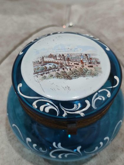 กระปุกแป้งน้ำเงิน ฝาบนภาพแสดงถึงสะพานอเล็กซานเดอร์ที่ 3 (Pont Alexandre III) ซึ่งเป็นสะพานที่สร้างขึ้นสำหรับงานนิทรรศการโลก  รูปที่ 2