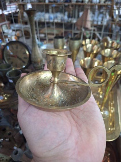 เชิงเทียนทองเหลืองแบบถือ มีด้ามจับ ตกแต่งลวดลายใบไม้และลายเส้นด้วยการตอกลายอย่างละเอียด เหมาะสำหรับแ