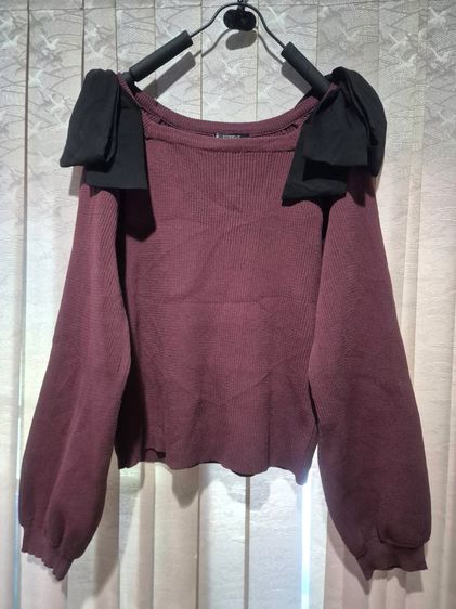 เสื้อสีแดงเลือดหมู แต่งโบว์สีดำบริเวณหัวไหล่ 2 ข้าง