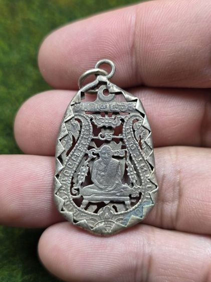 พระเหรียญฉลุสีเงินหลวงพ่อกันพร้อมเลี่ยมจับขอบเก่าๆ