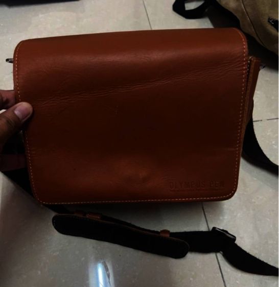 กระเป๋าสะพายหนังแบรนด์ Olympus รุ่น PEN เป็นกระเป๋าหนังฟอกฝาดสไตล์วินเทจหรือโมเดิร์นคลาสสิก. 