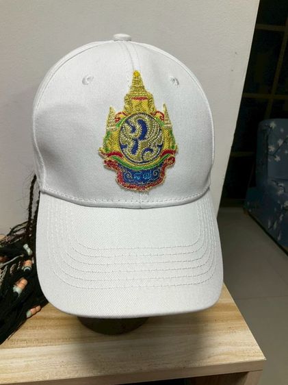 หมวกแก๊ปสีขาวปักตราสัญลักษณ์พระปรมาภิไธยย่อ ภ.ป.ร. มือหนึ่ง