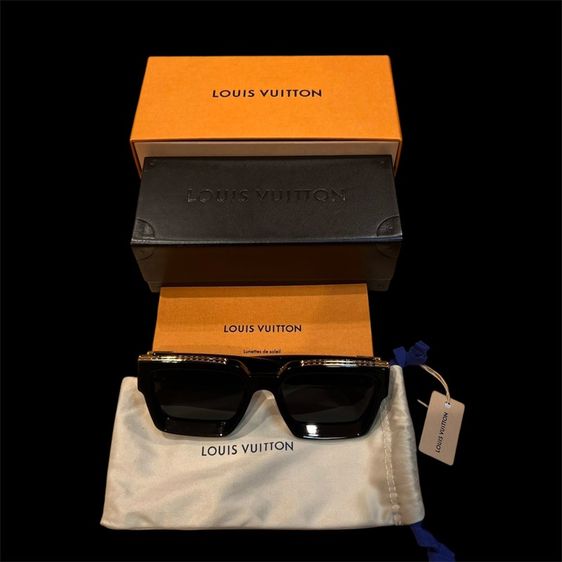 แว่นตากันแดด Louis Vuitton 1.1 Millionaires sunglasses feature a black, slanted frame with a striking gold Monogram pattern at the top full set