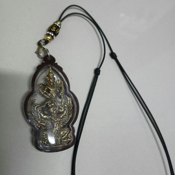 วัตถุมงคลในภาพดูเหมือนจะเป็น จี้พระนารายณ์ทรงครุฑปราบไตรจักร