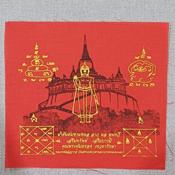 ผ้ายันต์มหามงคล "ลาภผลพูนทวี" สีแดง ซึ่งสร้างจากผ้าแดงที่ใช้ห่มองค์พระบรมสารีริกธาตุ (ภูเขาทอง) ของ วัดสระเกศ (ภูเขาทอง